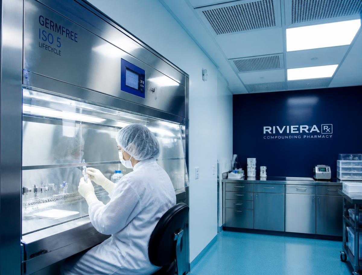 Compounding pharmacy cleanroom with a laminar flow hood and HEPA ceiling filters